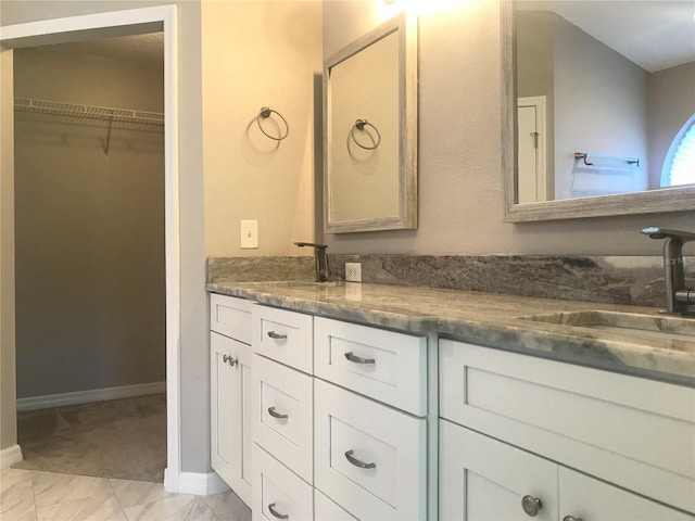 10969 Norcross Cir, Orlando, FL 32825 - full bathroom featuring double vanity, baseboards, and a spacious closet
