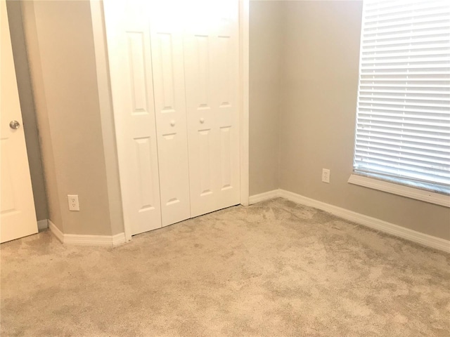 10969 Norcross Cir, Orlando, FL 32825 - unfurnished bedroom featuring light carpet, a closet, and baseboards