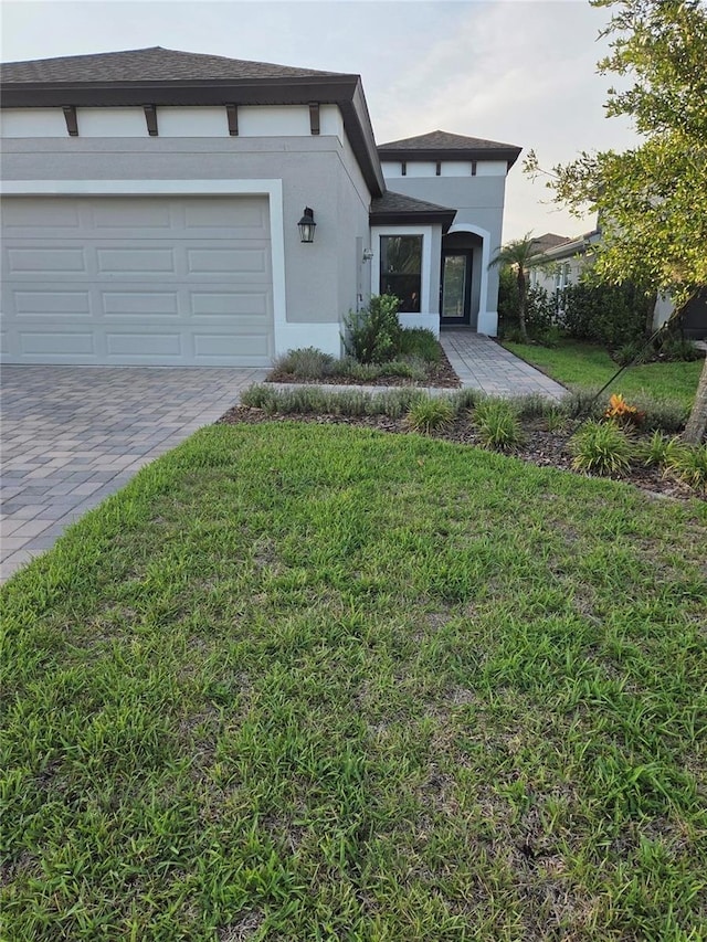 12513 Oak Hill Way, Parrish, FL 34219 - view of front of home with a front lawn, decorative driveway, stucco siding, and an attached garage