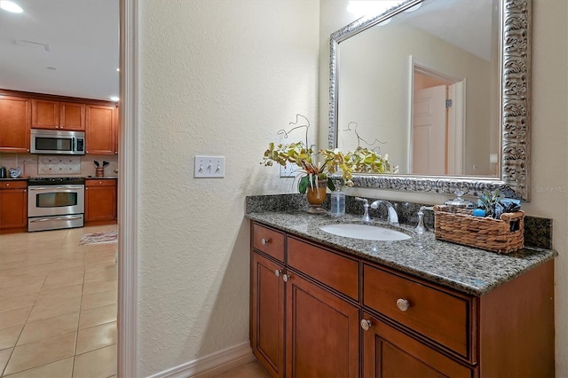 7616 Cabana Ct Unit 301, Reunion, FL 34747 - bathroom with a textured wall, vanity, decorative backsplash, and tile patterned floors