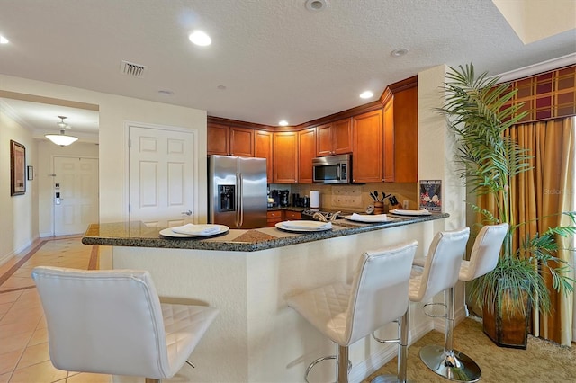 7616 Cabana Ct Unit 301, Reunion, FL 34747 - kitchen with stainless steel appliances, a kitchen bar, recessed lighting, a peninsula, and brown cabinetry