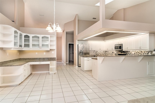 924 Texas St, Englewood, FL 34223 - kitchen with open shelves, appliances with stainless steel finishes, a kitchen bar, white cabinetry, and high vaulted ceiling