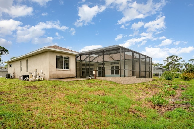 924 Texas St, Englewood, FL 34223 - rear view of property with stucco siding, central air condition unit, a lawn, and a lanai