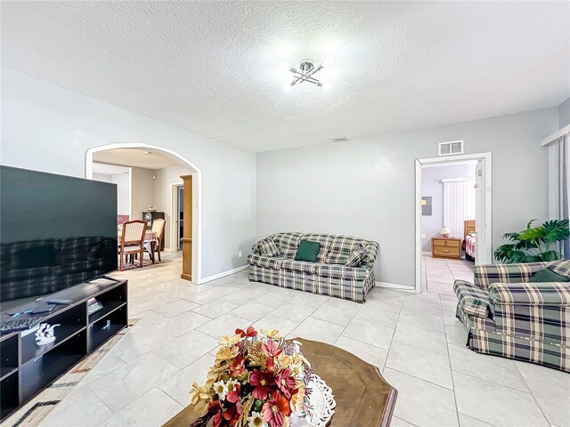 1826 W Silver Springs Blvd, Ocala, FL 34475 - living area with arched walkways, a textured ceiling, and baseboards