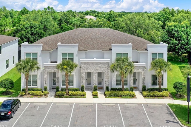 17441 Hidden Forest Dr, Clermont, FL 34714 - view of front facade featuring stone siding, uncovered parking, stucco siding, and french doors
