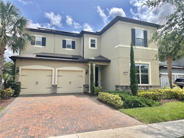 14117 Larkspur Lake Dr, Winter Garden, FL 34787 - view of front facade with stone siding, an attached garage, stucco siding, and decorative driveway