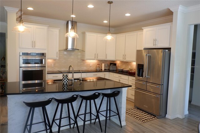 14117 Larkspur Lake Dr, Winter Garden, FL 34787 - kitchen with appliances with stainless steel finishes, wall chimney range hood, dark countertops, white cabinetry, and ornamental molding