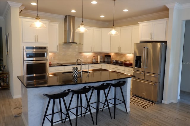 14117 Larkspur Lake Dr, Winter Garden, FL 34787 - kitchen featuring stainless steel appliances, wall chimney range hood, dark countertops, wood finished floors, and ornamental molding