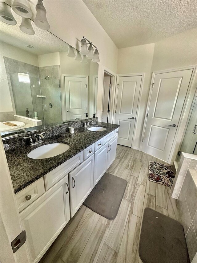 14117 Larkspur Lake Dr, Winter Garden, FL 34787 - full bath featuring a shower stall, double vanity, a textured ceiling, and wood finished floors
