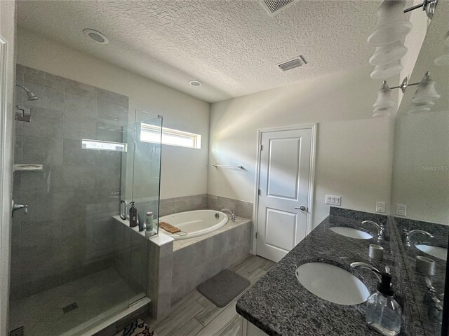 14117 Larkspur Lake Dr, Winter Garden, FL 34787 - bathroom featuring a garden tub, a stall shower, double vanity, and a textured ceiling