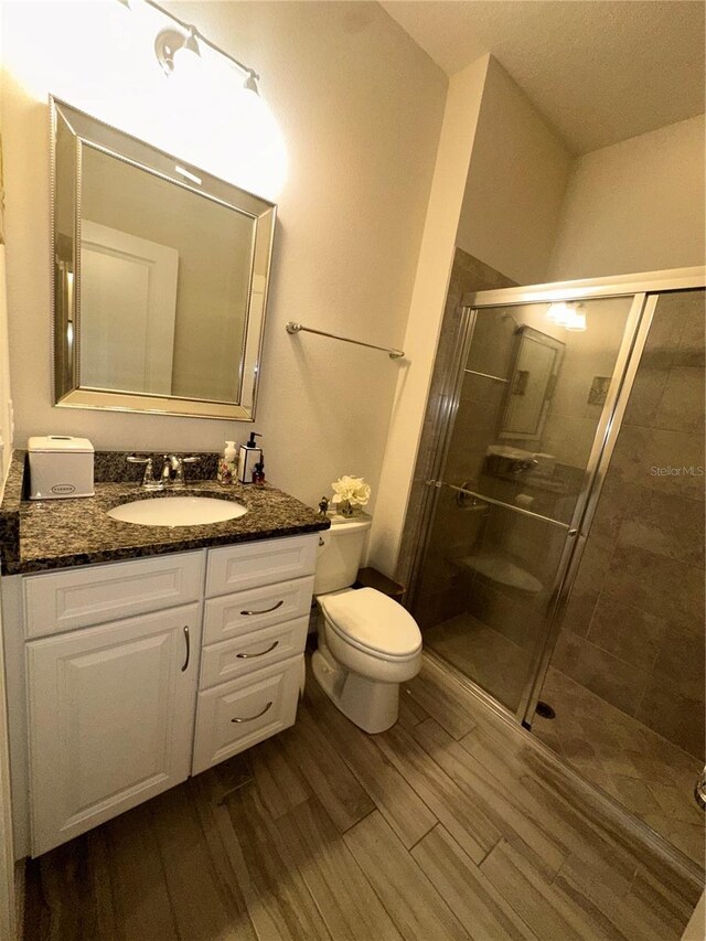 14117 Larkspur Lake Dr, Winter Garden, FL 34787 - full bathroom featuring wood finished floors, toilet, a shower stall, and vanity