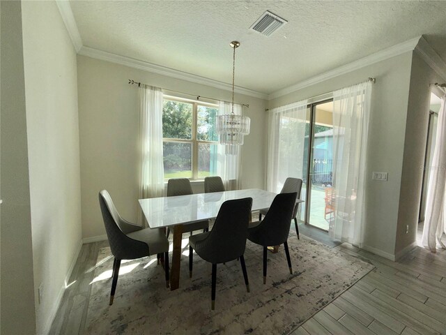 14117 Larkspur Lake Dr, Winter Garden, FL 34787 - dining space featuring a chandelier, ornamental molding, baseboards, wood finished floors, and a textured ceiling