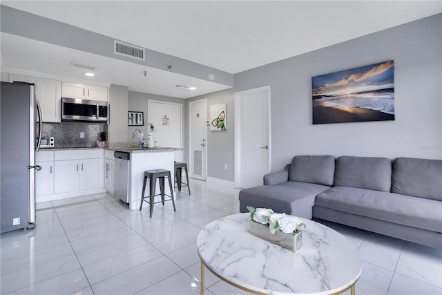 6165 Carrier Dr Unit 2605, Orlando, FL 32819 - living area with light marble finish flooring, baseboards, and recessed lighting