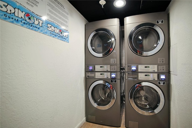 6165 Carrier Dr Unit 2605, Orlando, FL 32819 - community laundry featuring estacked washer and dryer, a textured wall, wood finished floors, washer and clothes dryer, and baseboards