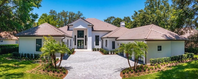 5199 Latrobe Dr, Windermere, FL 34786 - view of front of home featuring stucco siding, decorative driveway, a tile roof, and a front yard