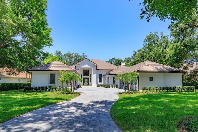 5199 Latrobe Dr, Windermere, FL 34786 - view of front of home featuring decorative driveway, stucco siding, a front lawn, a chimney, and a garage