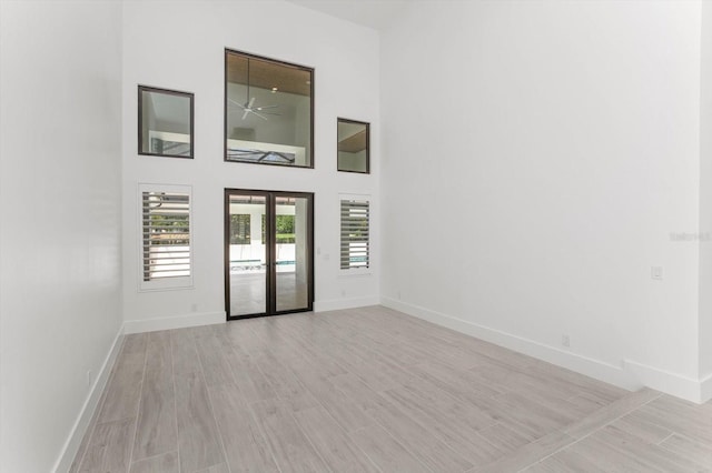 5199 Latrobe Dr, Windermere, FL 34786 - empty room with baseboards, french doors, light wood-type flooring, and a towering ceiling