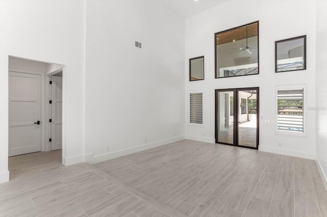 5199 Latrobe Dr, Windermere, FL 34786 - empty room featuring a high ceiling, light wood-style flooring, baseboards, french doors, and a ceiling fan