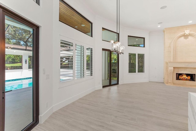 5199 Latrobe Dr, Windermere, FL 34786 - unfurnished living room featuring healthy amount of natural light, a chandelier, baseboards, recessed lighting, and a fireplace