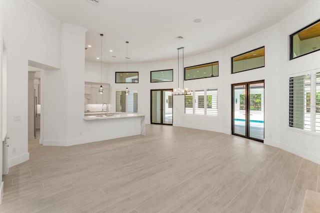 5199 Latrobe Dr, Windermere, FL 34786 - unfurnished living room with a chandelier, a sink, crown molding, baseboards, and a high ceiling