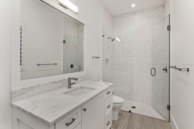 5199 Latrobe Dr, Windermere, FL 34786 - bathroom with toilet, vanity, a shower stall, wood finished floors, and recessed lighting