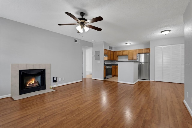351 Lone Hill Dr Unit 206, Altamonte Springs, FL 32701 - unfurnished living room featuring wood finished floors, a ceiling fan, baseboards, a tile fireplace, and a textured ceiling