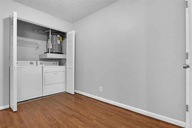 351 Lone Hill Dr Unit 206, Altamonte Springs, FL 32701 - laundry room featuring washing machine and dryer, baseboards, a textured ceiling, and hardwood / wood-style floors