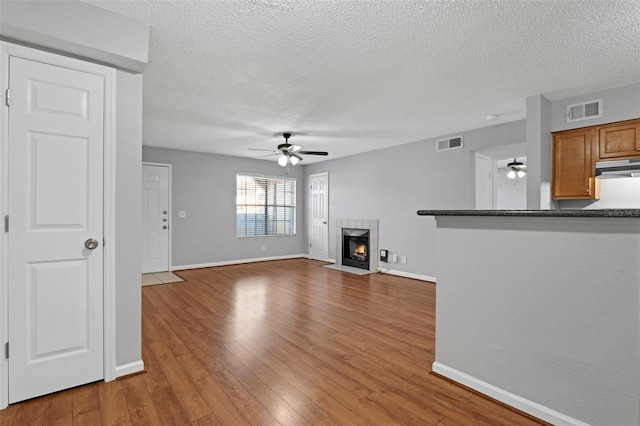 351 Lone Hill Dr Unit 206, Altamonte Springs, FL 32701 - unfurnished living room featuring ceiling fan, baseboards, a fireplace, and a textured ceiling
