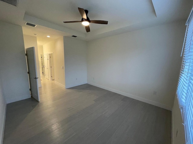 10153 Wildcat St, Port Charlotte, FL 33981 - spare room featuring ceiling fan, dark wood-style flooring, baseboards, and a raised ceiling