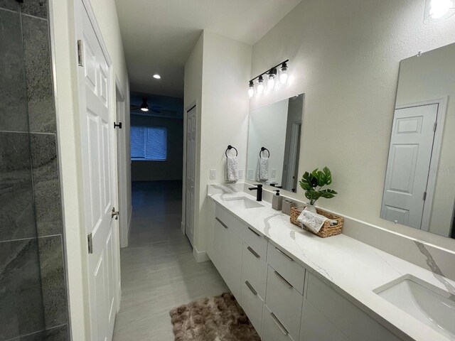 10153 Wildcat St, Port Charlotte, FL 33981 - bathroom with double vanity, recessed lighting, wood finished floors, and a ceiling fan