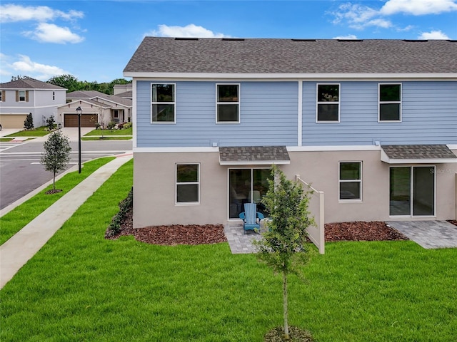 3345 Thicket St, Tavares, FL 32778 - back of house featuring roof with shingles, a yard, and stucco siding