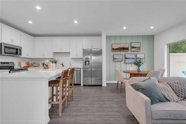 3345 Thicket St, Tavares, FL 32778 - kitchen with stainless steel appliances, a breakfast bar, recessed lighting, white cabinetry, and light countertops