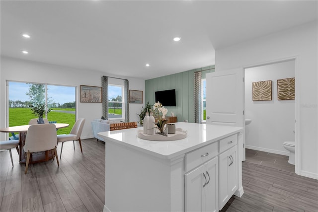 3345 Thicket St, Tavares, FL 32778 - kitchen with a kitchen island, white cabinets, light countertops, recessed lighting, and wood finished floors