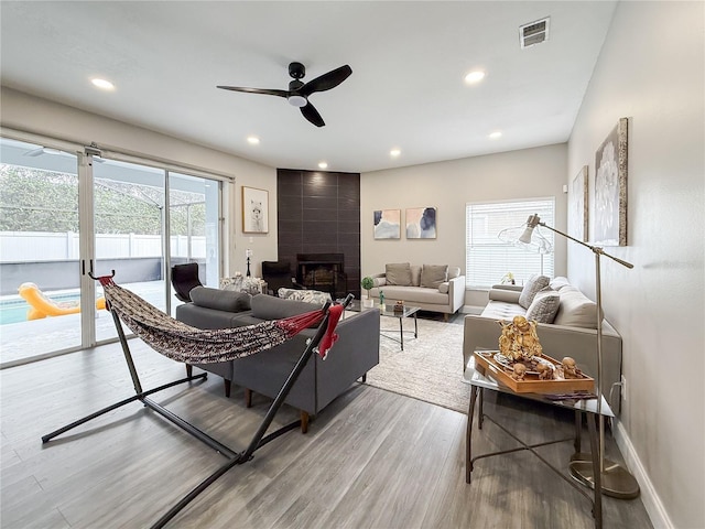 224 Hammock Dunes Pl, Orlando, FL 32828 - living area with wood finished floors, ceiling fan, a fireplace, baseboards, and recessed lighting