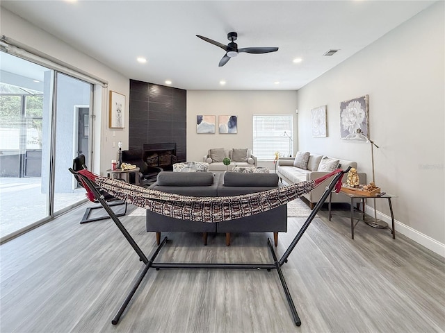 224 Hammock Dunes Pl, Orlando, FL 32828 - living area featuring light wood finished floors, a ceiling fan, recessed lighting, a fireplace, and baseboards