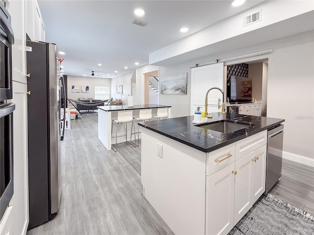224 Hammock Dunes Pl, Orlando, FL 32828 - kitchen with a sink, appliances with stainless steel finishes, a center island with sink, light wood finished floors, and open floor plan