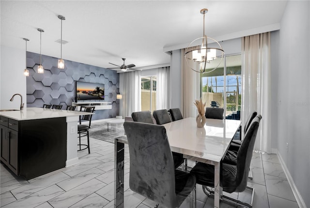 8961 Cabot Cliffs Dr, Davenport, FL 33896 - dining room featuring light marble finish floors, baseboards, a chandelier, an accent wall, and a ceiling fan