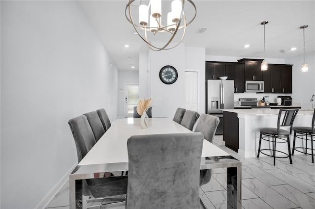 8961 Cabot Cliffs Dr, Davenport, FL 33896 - dining area featuring light marble finish floors, a chandelier, and recessed lighting