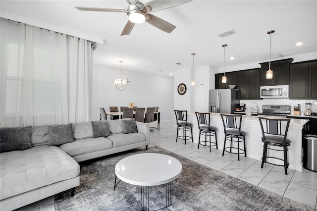 8961 Cabot Cliffs Dr, Davenport, FL 33896 - living room featuring light marble finish flooring, ceiling fan, recessed lighting, and a chandelier