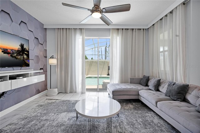 8961 Cabot Cliffs Dr, Davenport, FL 33896 - living room with ceiling fan, baseboards, marble finish flooring, and a textured ceiling