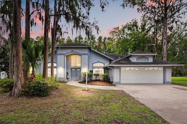 4026 S Lake Orlando Pkwy, Orlando, FL 32808 - view of front of home with stucco siding, an attached garage, driveway, and a front yard