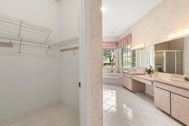 4026 S Lake Orlando Pkwy, Orlando, FL 32808 - full bath with a stall shower, double vanity, wallpapered walls, a spacious closet, and tile patterned flooring