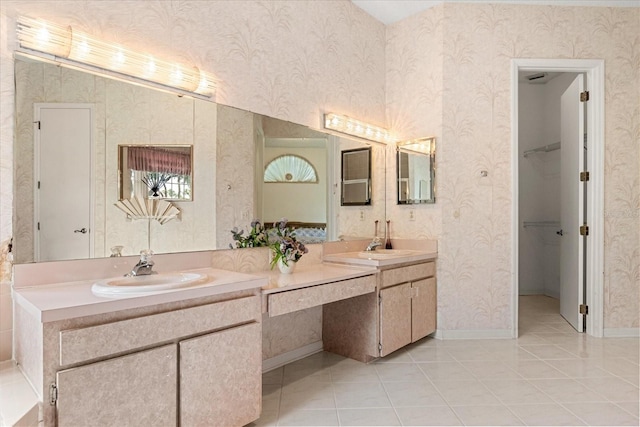 4026 S Lake Orlando Pkwy, Orlando, FL 32808 - bathroom with double vanity, tile patterned floors, a spacious closet, wallpapered walls, and baseboards