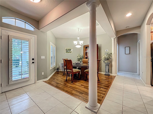 1701 Lucky Pennie Way, Apopka, FL 32712 - entrance foyer featuring light tile patterned floors, decorative columns, arched walkways, baseboards, and a chandelier