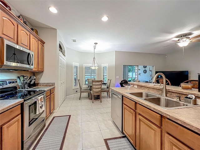 1701 Lucky Pennie Way, Apopka, FL 32712 - kitchen featuring stainless steel appliances, a sink, light tile patterned floors, hanging light fixtures, and light countertops
