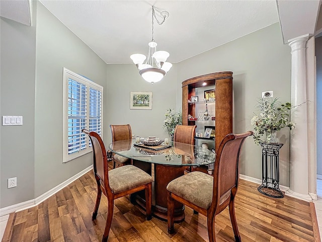 1701 Lucky Pennie Way, Apopka, FL 32712 - dining space featuring wood finished floors, baseboards, ornate columns, and a chandelier