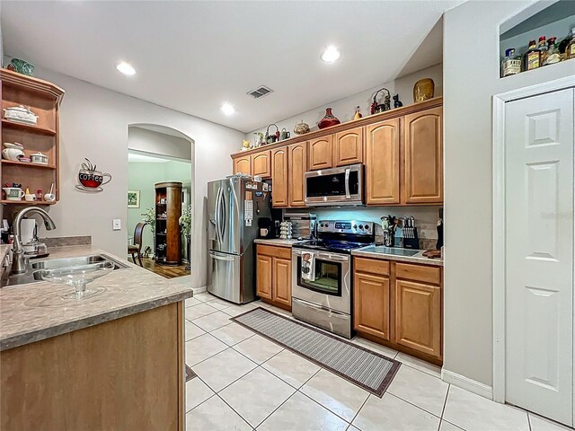 1701 Lucky Pennie Way, Apopka, FL 32712 - kitchen with appliances with stainless steel finishes, a sink, arched walkways, light tile patterned flooring, and open shelves