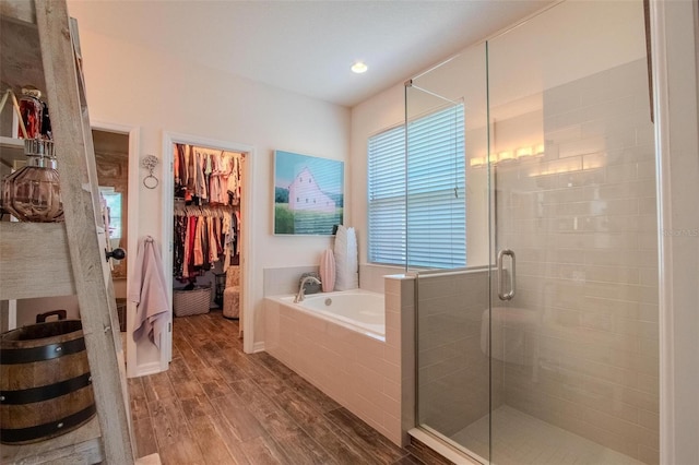 13940 Magnolia Ridge Loop, Winter Garden, FL 34787 - bathroom featuring wood finished floors, a bath, a walk in closet, and a shower stall