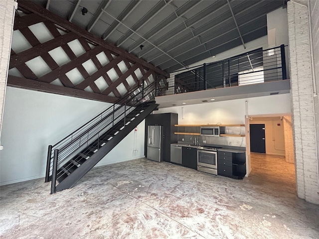 62 W Colonial Dr Unit 302, Orlando, FL 32801 - kitchen featuring high vaulted ceiling, stainless steel appliances, open shelves, and dark cabinets
