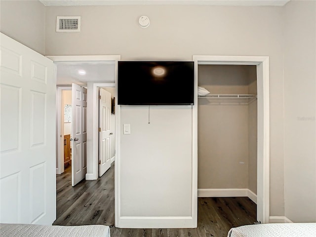931 S Orlando Ave, Cocoa Beach, FL 32931 - unfurnished bedroom featuring a closet, dark wood-style floors, a walk in closet, and baseboards